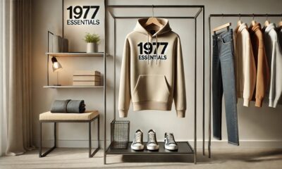 The 1977 Essentials Hoodie displayed on a minimalist setup with neutral tones and stylish accessories.