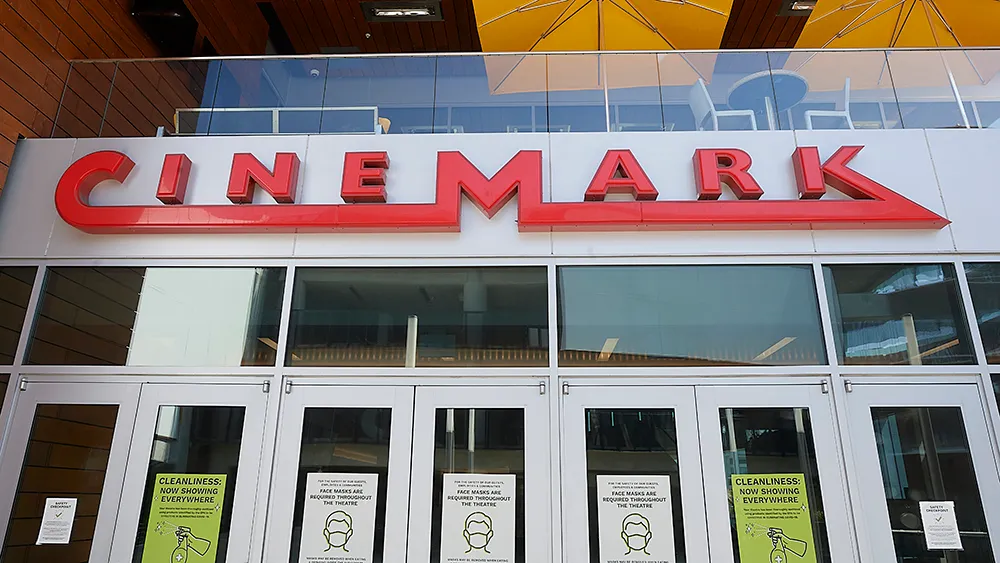 A Cinemark theater exterior with moviegoers entering to watch the latest films.