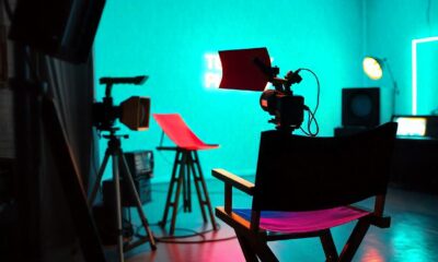 A creative representation of a tellyplay production process showcasing a script, a director's chair, and television camera on set.